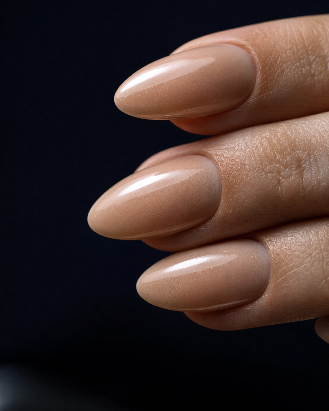 Medium length almond shaped press-on nails in a warm sheer beige