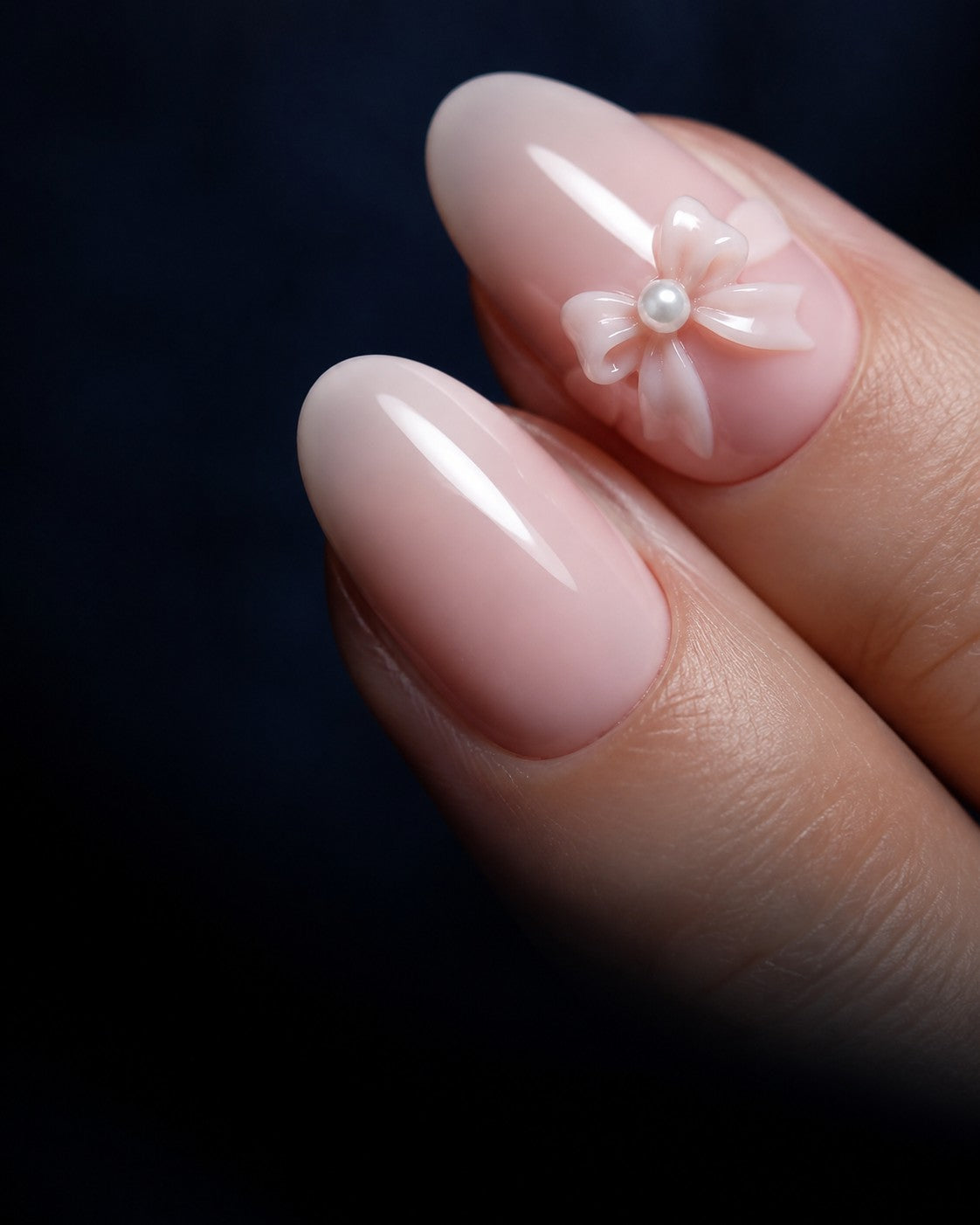 Blush pink coquette press-on nails with a sculpted bow and a single pearl