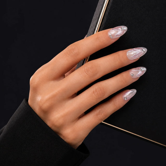 Aurora Pearl Press-On Nails, Almond Medium — Main sur pochette noire (liseré doré)