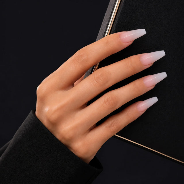 Bare Ballerina Press-On Nails, Coffin Long — Main sur pochette noire (liseré doré)