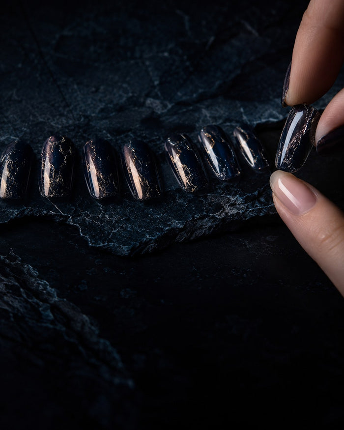 Press-on nail tips laid out in graduated sizes, one being checked against a natural nail