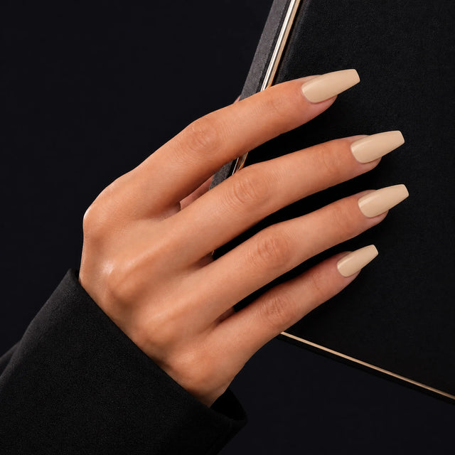 Latte Press-On Nails, Medium Coffin — Main sur pochette noire (liseré doré)