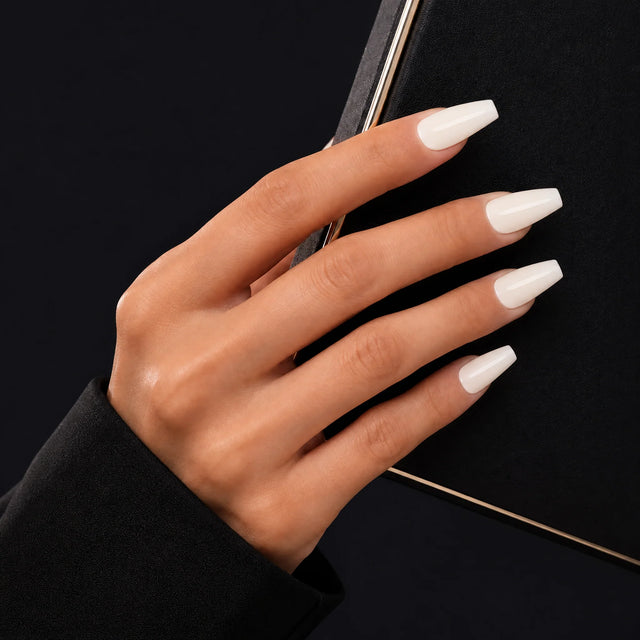 Milk Glaze Press-On Nails, Medium Coffin — Main sur pochette noire (liseré doré)