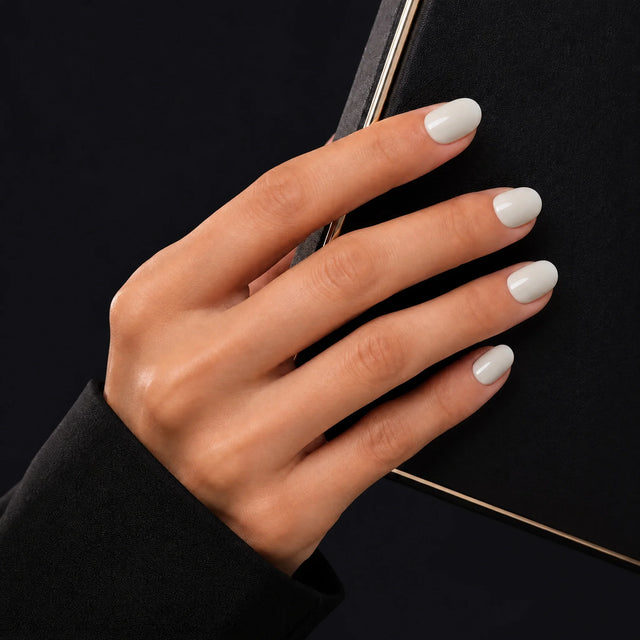 Milk Glaze Press-On Nails, Short Oval — Main sur pochette noire (liseré doré)