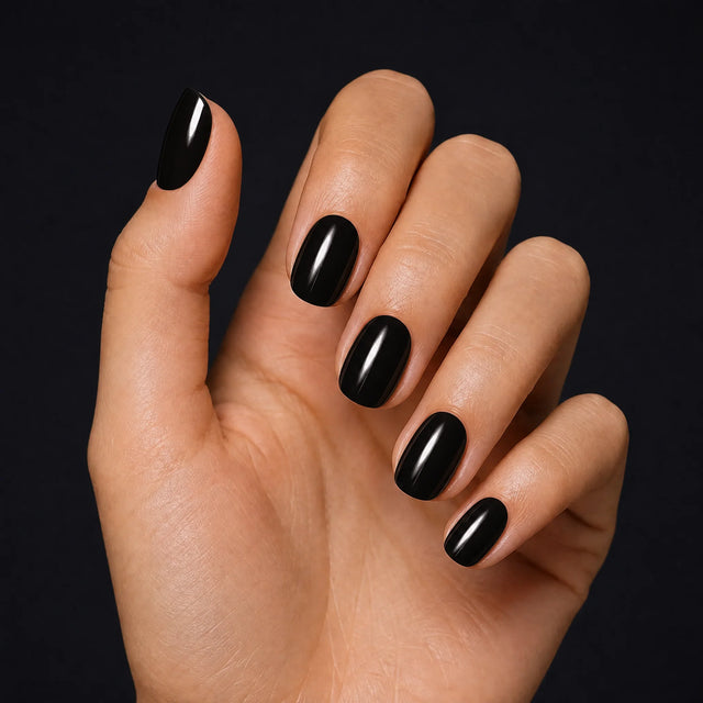 Noir Press-On Nails, Short Oval — Hero — une main, fond noir