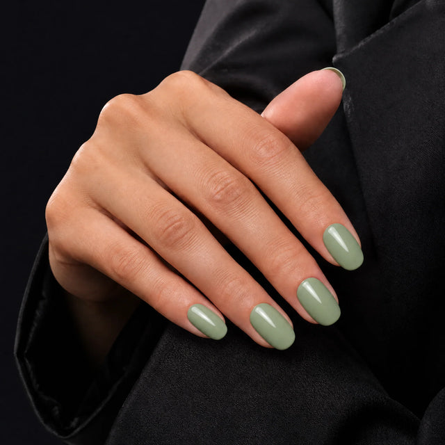 Sage Press-On Nails, Short Oval — Main sur blazer noir (dos de main)