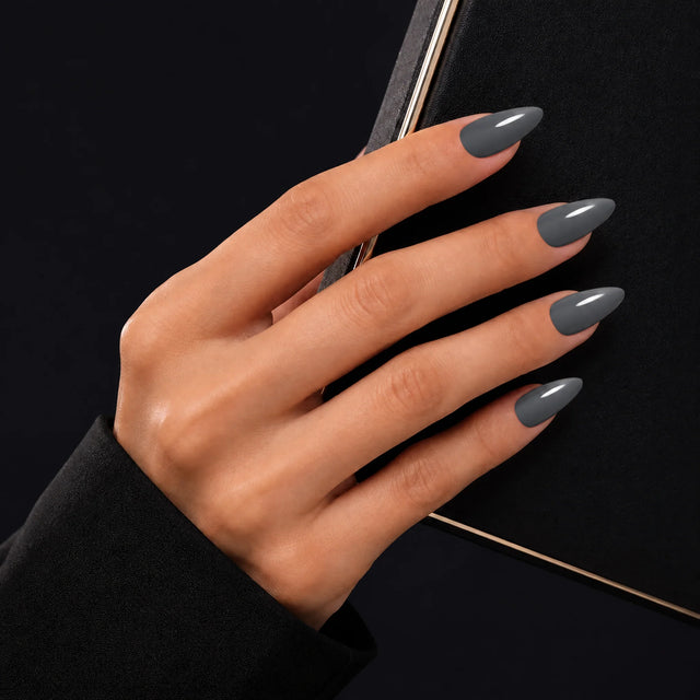 Slate Press-On Nails, Medium Almond — Main sur pochette noire (liseré doré)