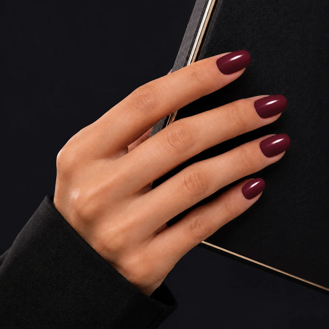 Wine Press-On Nails, Short Oval — Main sur pochette noire (liseré doré)
